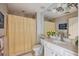 Cozy bathroom with a single sink vanity, a large mirror, and a shower with a decorative yellow patterned curtain at 33 Calhoun St # 218, Charleston, SC 29401