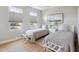 Bright bedroom featuring two twin beds, light hardwood floors, and two sunny windows with modern cellular shades at 33 Calhoun St # 218, Charleston, SC 29401