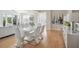 Bright dining area with a glossy white table and chairs, next to living area and stylish art at 33 Calhoun St # 218, Charleston, SC 29401
