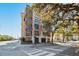Stunning exterior view of a modern condo building, showcasing its brick facade, balconies, and well-manicured landscaping at 33 Calhoun St # 218, Charleston, SC 29401