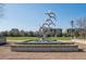 Park featuring a modern bird sculpture fountain, a grassy field, and nearby buildings at 33 Calhoun St # 218, Charleston, SC 29401