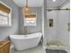 Spa-like bathroom with a freestanding tub, walk-in shower, woven pendant light, and natural light from the window at 4258 Jacobs Pt Ct, Ravenel, SC 29470