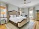 Cozy bedroom features a king-size bed, hardwood floors, ample natural light, and stylish decor at 4258 Jacobs Pt Ct, Ravenel, SC 29470