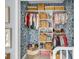 Nicely organized closet with floral wallpaper, a wardrobe, and storage baskets at 4258 Jacobs Pt Ct, Ravenel, SC 29470