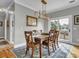 Bright dining room with wood table, chairs, stylish light fixture, and sliding doors to the outside at 4258 Jacobs Pt Ct, Ravenel, SC 29470
