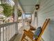 Inviting front porch with rocking chairs, coastal decor, and picturesque views of palm trees and the neighborhood at 4258 Jacobs Pt Ct, Ravenel, SC 29470