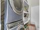 Convenient laundry room features stacked washer and dryer with shelving for organized storage at 4258 Jacobs Pt Ct, Ravenel, SC 29470