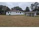 Large, grassy backyard featuring a white house and detached covered parking area at 488 Society Rd # A&B, McClellanville, SC 29458