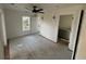Bright bedroom with white walls, ceiling fan, two windows, and an entrance to a bathroom at 515 Joseph St, Charleston, SC 29412