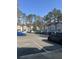 View of the parking lot with a row of residential townhomes featuring mature trees and an open community setting at 531 Travelers Blvd, Summerville, SC 29485