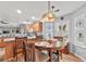 Bright dining area features stylish lighting, a wooden table, and views into the kitchen at 600 Elm Hall Cir, Summerville, SC 29483