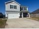 Two-story home with gray siding, a two-car garage, and a well-maintained lawn and long concrete driveway at 619 Ravens Wood Rd, Summerville, SC 29486