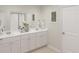 Bright bathroom with double vanity, white cabinets, framed mirrors, and elegant floral arrangement at 621 Red Monarch Way, Moncks Corner, SC 29461
