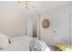 Bright bedroom with a patterned wall, stylish light fixture, and white bedding, creating a cozy and inviting space at 621 Red Monarch Way, Moncks Corner, SC 29461