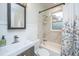 Well-lit bathroom featuring tiled shower and tub, vanity with sink, and floral shower curtain at 69 Folly Road Blvd, Charleston, SC 29407