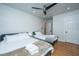 Bright bedroom featuring two beds, ceiling fan, fresh white bedding, and a doorway at 69 Folly Road Blvd, Charleston, SC 29407