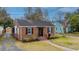 Charming brick home with black shutters, a well-manicured lawn, and inviting curb appeal at 69 Folly Road Blvd, Charleston, SC 29407