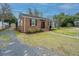 Charming brick home with manicured lawn, black shutters, and brick walkway leading to the front door at 69 Folly Road Blvd, Charleston, SC 29407