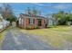 Charming single story brick home featuring a new roof, a long driveway, and manicured landscape at 69 Folly Road Blvd, Charleston, SC 29407