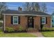 Charming brick home with black shutters, manicured landscaping, and a brick pathway to the front door at 69 Folly Road Blvd, Charleston, SC 29407