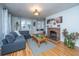 Bright living room featuring a brick fireplace, a gray sofa, hardwood floors, and natural light at 69 Folly Road Blvd, Charleston, SC 29407