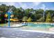 Community pool with zero entry area, bucket water feature, and lounge chairs under umbrellas at 960 Carnes Xing, Summerville, SC 29486