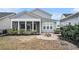 Backyard showcasing a screened-in porch, detached garage, and inviting brick fire pit area at 119 Philips Park St, Summerville, SC 29486