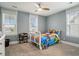 Bright bedroom featuring a fan, three windows, a closet, and a white bed with colorful bedding at 119 Philips Park St, Summerville, SC 29486