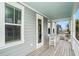 Relaxing covered porch with a white dining set and scenic neighborhood views at 119 Philips Park St, Summerville, SC 29486