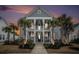 Charming two-story home with a welcoming porch, swing, and lush landscaping at sunset at 119 Philips Park St, Summerville, SC 29486