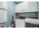 Well-equipped laundry room with modern washer/dryer, storage cabinets, and neutral color palette at 119 Philips Park St, Summerville, SC 29486