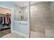 Bright shower featuring gray tiling, a glass shower door, and a shower head, and a view to the walk-in closet at 119 Philips Park St, Summerville, SC 29486