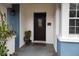Inviting front door featuring a dark wood door with decorative glass, accented by plants and exterior lighting at 1216 Eastwood Ave, Hanahan, SC 29410
