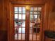 View through the paned doors to the hardwood floor, fireplace, and window-filled dining area of the living room at 1216 Eastwood Ave, Hanahan, SC 29410