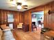 Living room with hardwood floors and wood paneled walls offers access to another living area with fireplace at 1216 Eastwood Ave, Hanahan, SC 29410