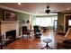 This warm living room features a fireplace, hardwood floors, natural light, and a view to the dining area at 1216 Eastwood Ave, Hanahan, SC 29410