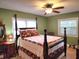 Comfortable main bedroom with a four-poster bed, soft green walls, ceiling fan and two windows at 1216 Eastwood Ave, Hanahan, SC 29410