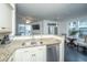Open-concept kitchen featuring granite countertops, stainless steel dishwasher, and views of the living area at 130 River Landing Dr # 7123, Charleston, SC 29492