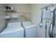 A functional laundry room with washer, dryer, shelving, and cleaning supplies at 130 River Landing Dr # 7123, Charleston, SC 29492