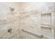 Tiled shower stall featuring a rainfall shower head, grab bar, and built-in shelving at 130 River Landing Dr # 7123, Charleston, SC 29492