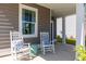 Inviting front porch with rocking chairs, a small table, and a view of the well-maintained lawn at 131 Threaded Fern St, Summerville, SC 29485