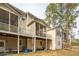 Rear view of a home showcasing backyards, wood siding, and upper screened patios at 136 Fair Sailing Rd, Mount Pleasant, SC 29466