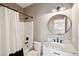 Modern bathroom with a shower and a round mirror above a granite sink at 136 Fair Sailing Rd, Mount Pleasant, SC 29466