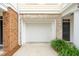 Attached garage with a white door, brick trim, and green bushes in front at 136 Fair Sailing Rd, Mount Pleasant, SC 29466