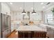 Bright kitchen with an island, stainless steel appliances, white cabinets, and modern pendant lighting at 136 Fair Sailing Rd, Mount Pleasant, SC 29466