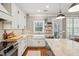 White farmhouse sink, tiled backsplash, with view from window and stainless dishwasher at 136 Fair Sailing Rd, Mount Pleasant, SC 29466