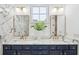 Luxurious bathroom with marble countertop, double vanity, gold fixtures, and decorative mirror lighting at 1433 Lettered Olive Ln, Mount Pleasant, SC 29464