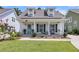 Charming single-Gathering home with a welcoming front porch, well-maintained lawn, and beautiful landscaping at 1710 Sparkleberry Ln, Johns Island, SC 29455