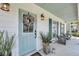 Inviting front porch featuring a decorative wreath, stylish lanterns, and comfortable seating at 1710 Sparkleberry Ln, Johns Island, SC 29455