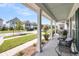 Relaxing front porch with seating area and views of the manicured lawn and quiet street at 1710 Sparkleberry Ln, Johns Island, SC 29455
